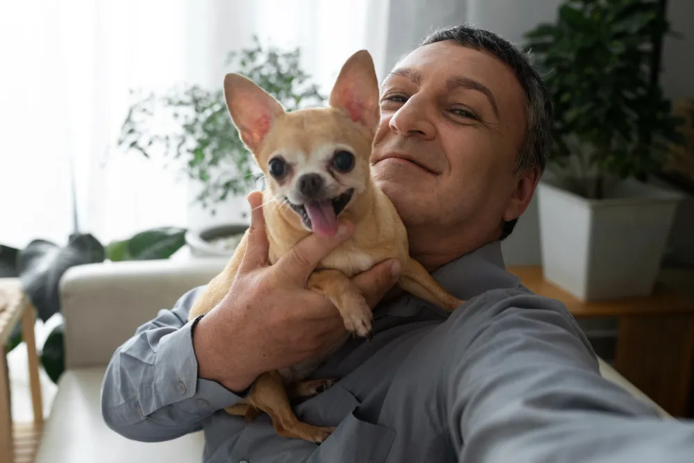 A man holding a small dog in his arms.